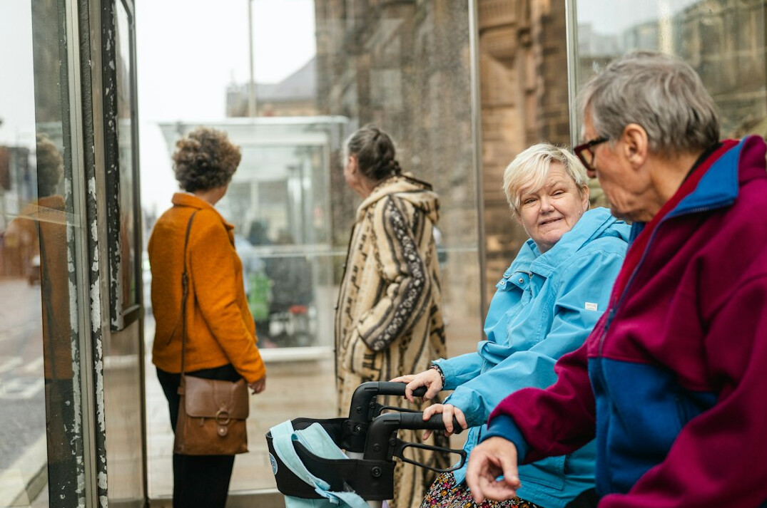 Group of smiling senior friends sitting together and laughing in a cozy community room